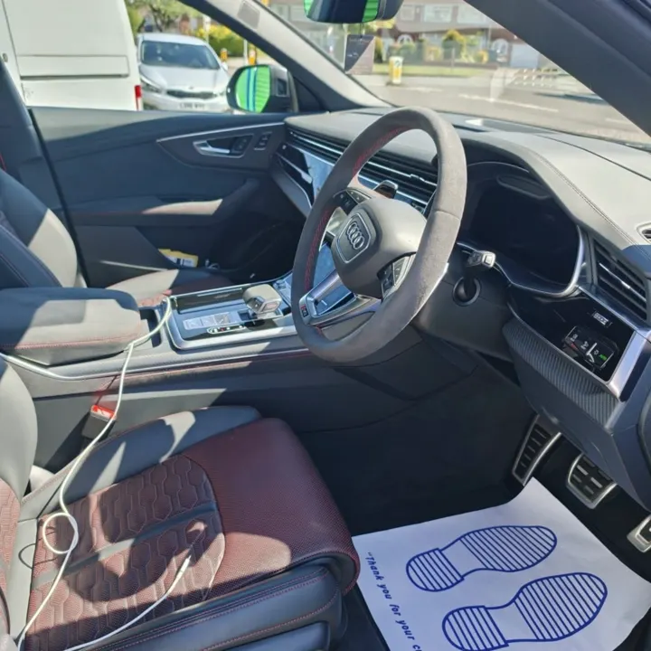 Audi interior with a protective paper floor mat in place, photographed on a customer's driveway