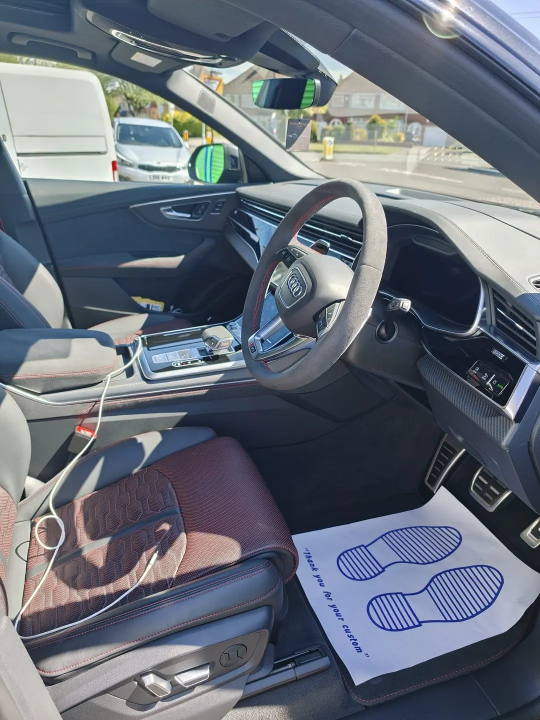 Audi cabin with a protective paper floor mat in place during an interior detail