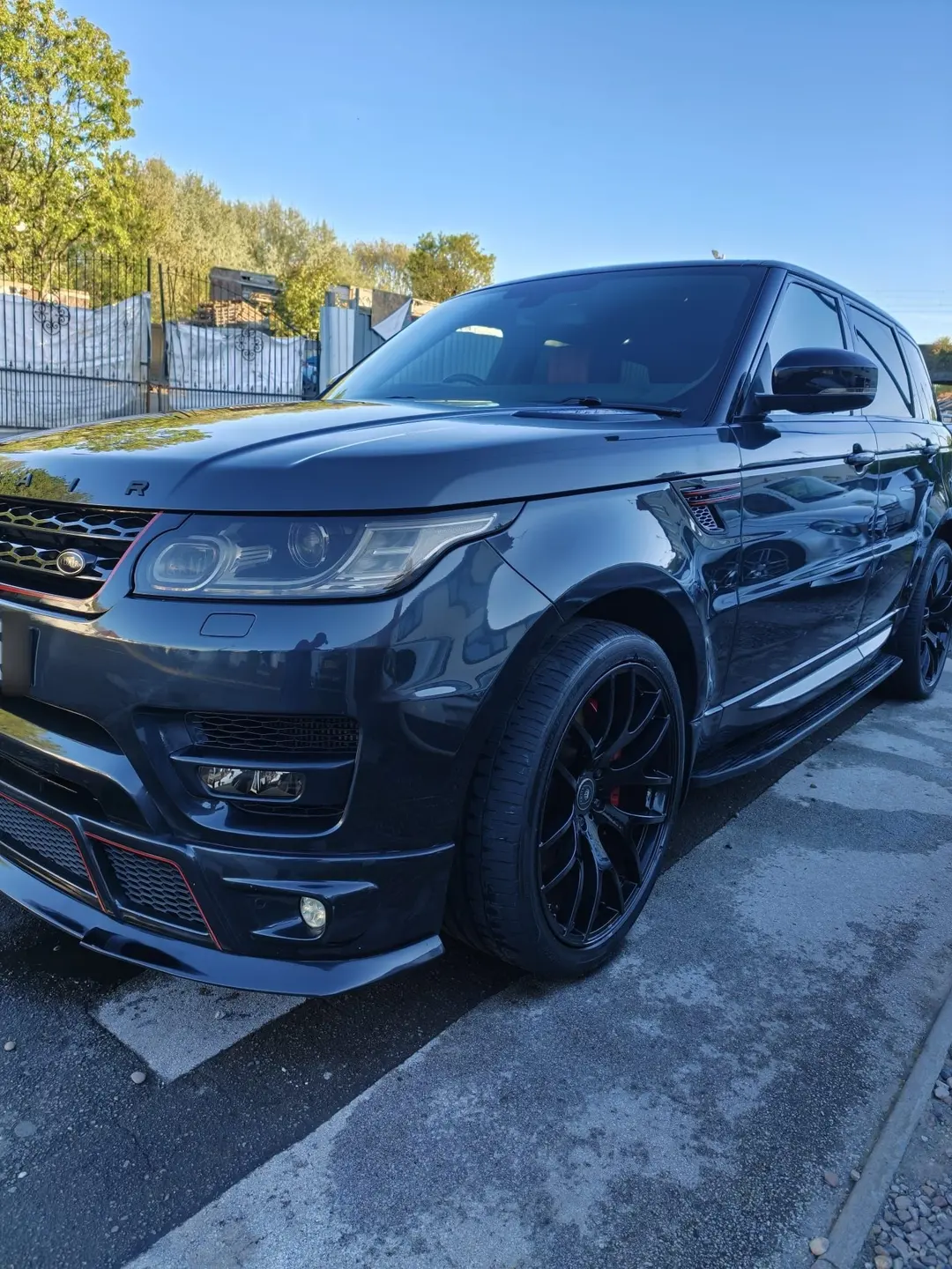Dark grey Range Rover Sport parked outdoors in sunshine